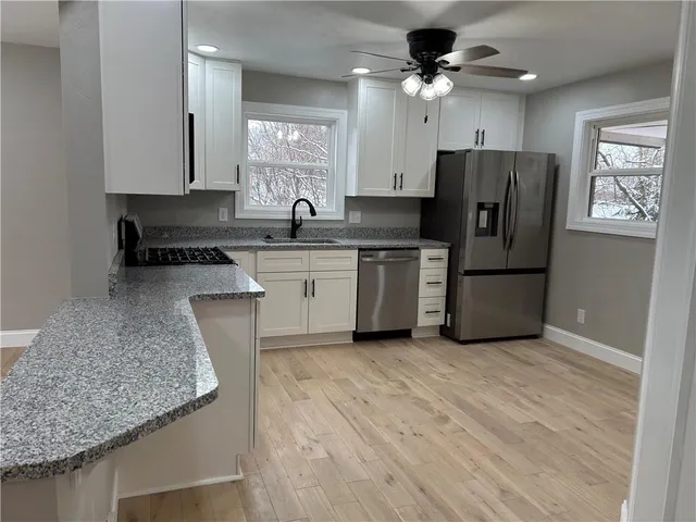a kitchen with stainless steel appliances granite countertop a sink stove and refrigerator