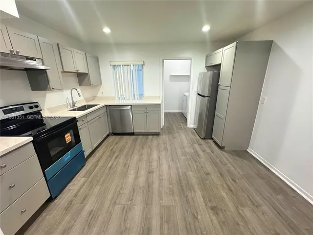 a kitchen with a refrigerator a sink and cabinets