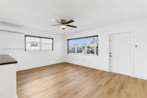 a view of an empty room with a window and a ceiling fan
