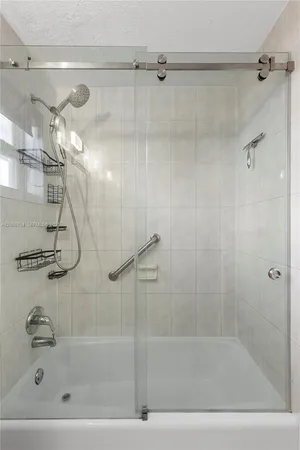 a bathroom with a shower and a bath tub