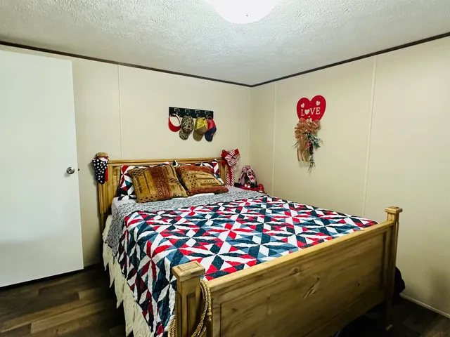 a bedroom with a bed and a painting on the wall