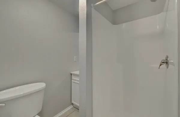 a white toilet sitting next to a white wall
