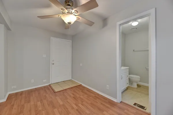 wooden floor in an empty room with a bathroom