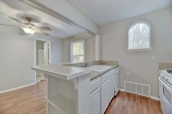 a view of a kitchen sink and wooden floor