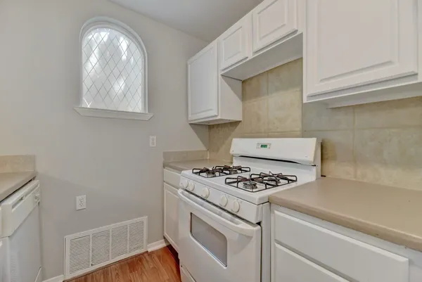 a kitchen with white cabinets and a stove