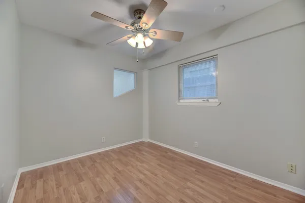 a view of an empty room with a chandelier fan