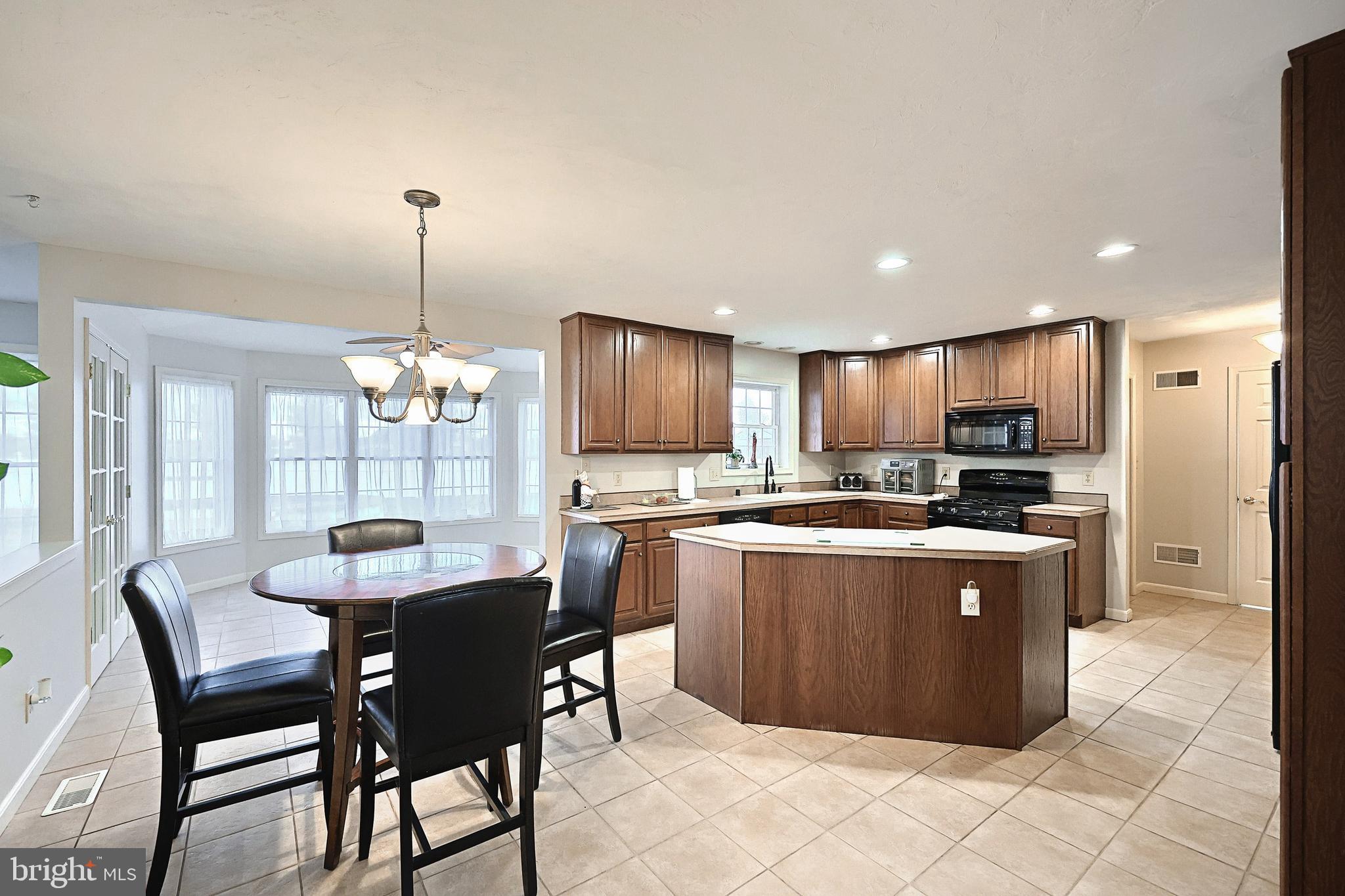 37 Amanda Drive Littlestown, PA 17340 - Photo 30 of 70 a kitchen with stainless steel appliances kitchen island granite countertop a table chairs and a wooden cabinets