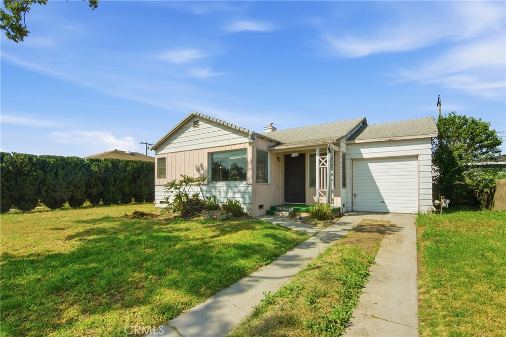 615 North Grandee Avenue Compton, CA 90220 - Photo 2 of 14 a front view of a house with a garden and yard
