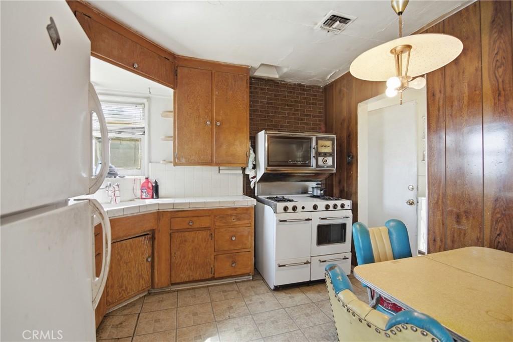 615 North Grandee Avenue Compton, CA 90220 - Photo 5 of 14 a kitchen that has a sink a stove top oven a chimney a dining table and chairs