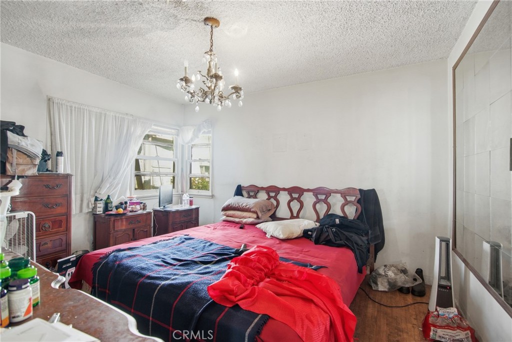 615 North Grandee Avenue Compton, CA 90220 - Photo 9 of 14 a bedroom with a bed and a chandelier