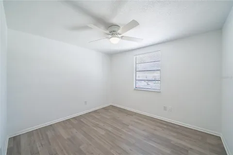 an empty room with a window and ceiling fan