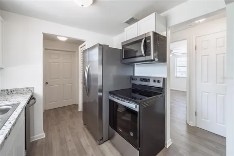 a kitchen with stainless steel appliances granite countertop a stove a refrigerator and a microwave