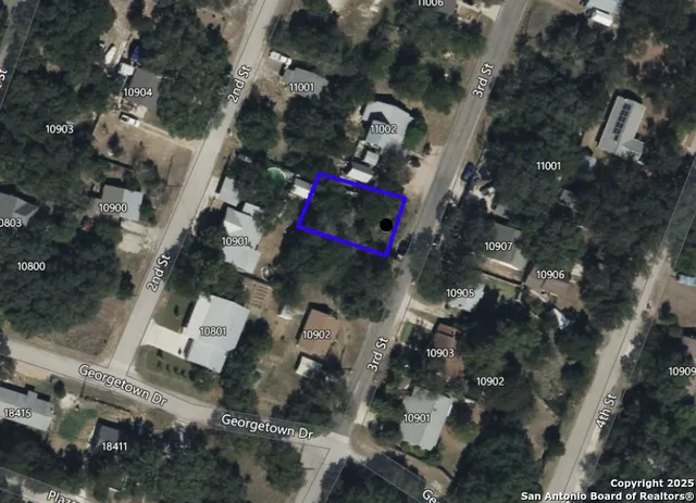 an aerial view of a house with a yard and parking