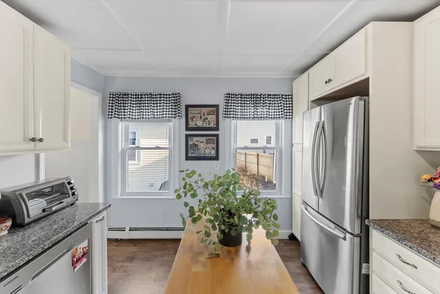 a kitchen with granite countertop a sink stove and cabinets