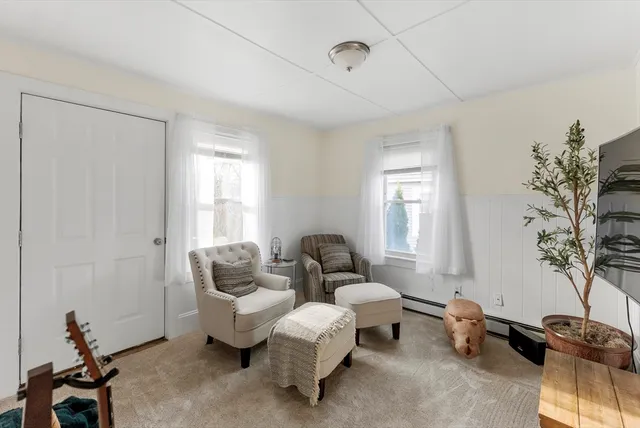 a living room with furniture a flat screen tv and a window