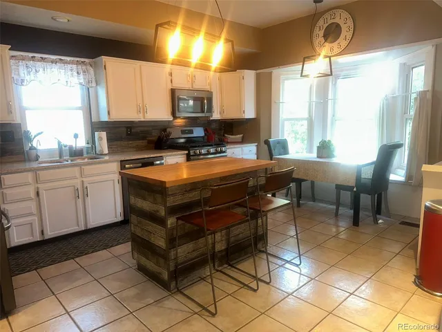 a view of a livingroom with wooden floor and furniture
