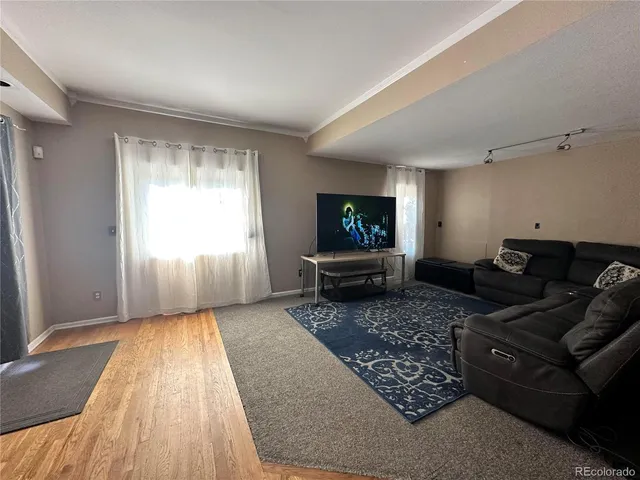 a bed sitting in a spacious bedroom next to a larger window