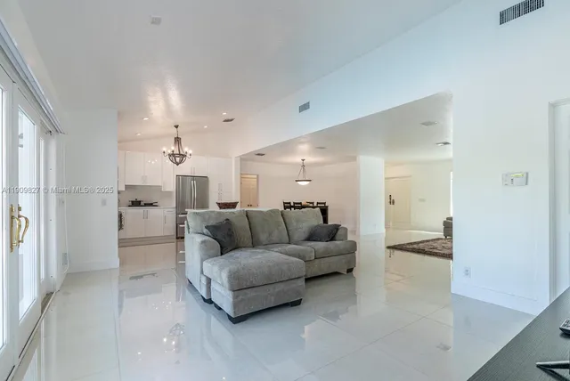 a living room with furniture and a view of kitchen