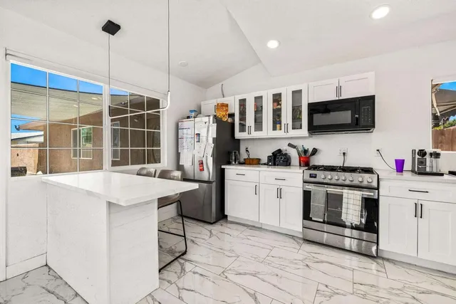 a kitchen with stainless steel appliances kitchen island granite countertop a sink and cabinets