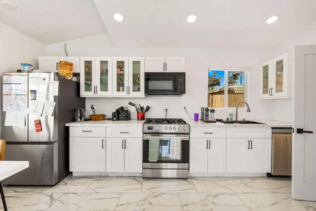 a kitchen with stainless steel appliances granite countertop a stove and cabinets