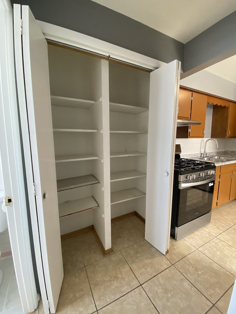 4345 West 63rd Street, Unit 2D Chicago, IL 60629 - Photo 7 of 12 a kitchen with white cabinets and appliances