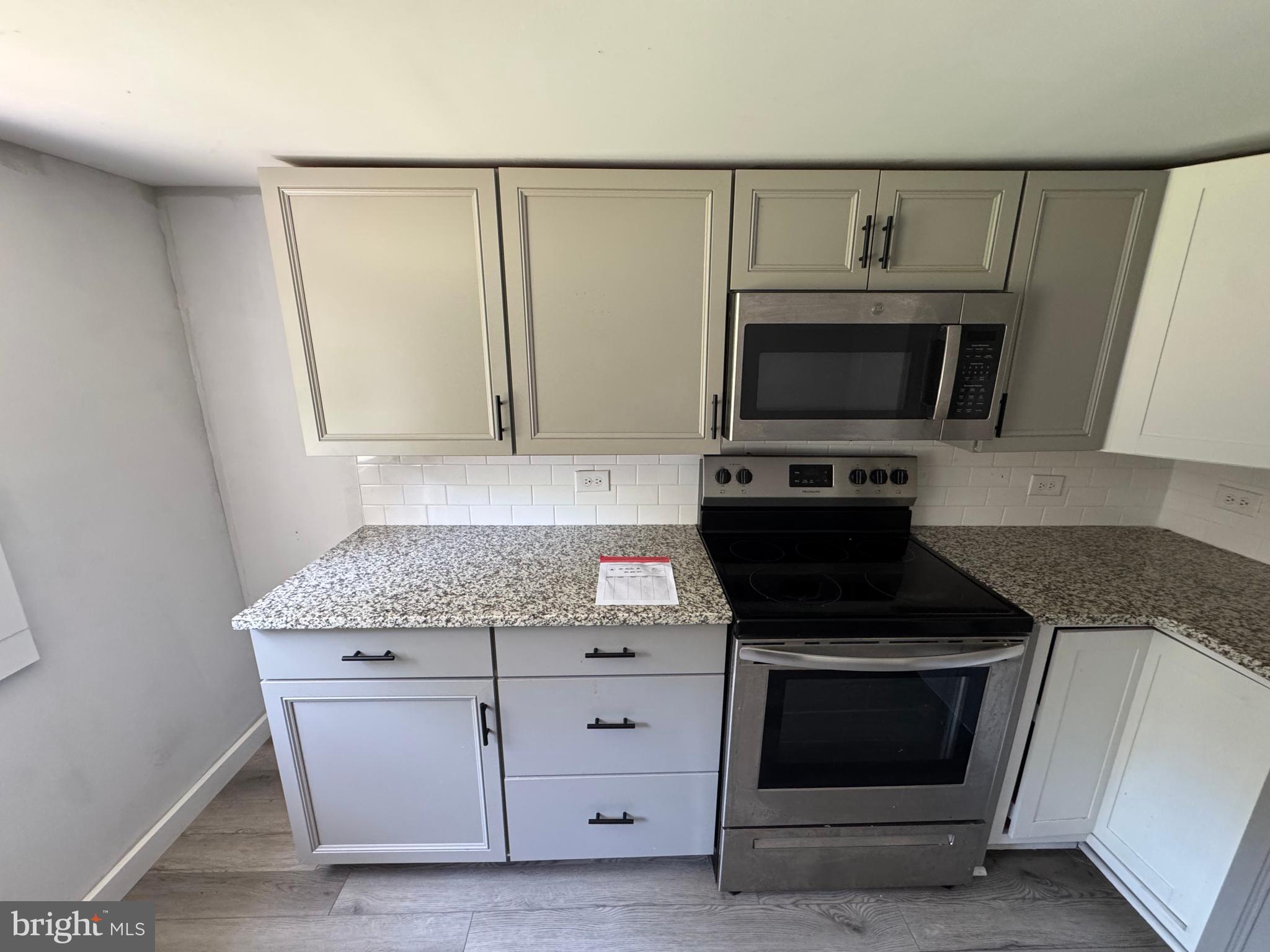 395 Tansboro Road Berlin, NJ 08009 - Photo 15 of 47 a kitchen with granite countertop white cabinets and stainless steel appliances