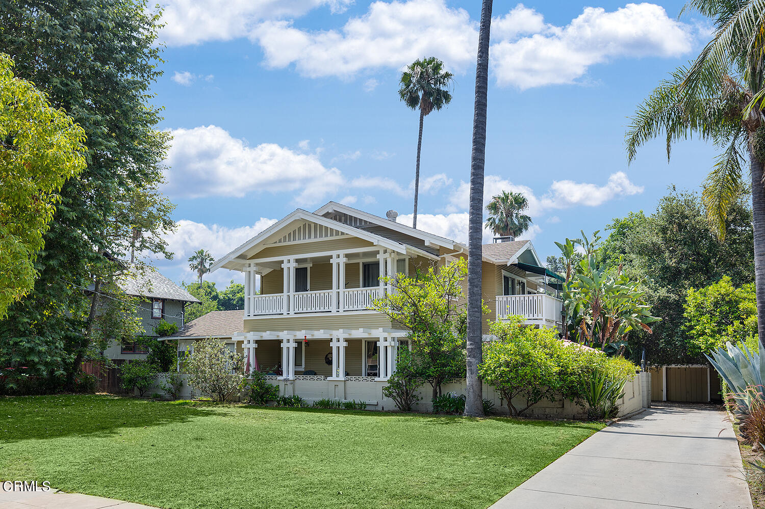 a front view of a house with a yard and potted plants