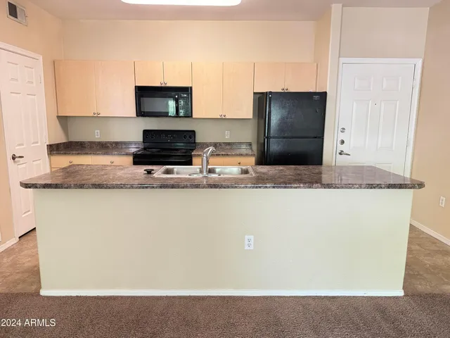 a kitchen with granite countertop a refrigerator and a stove