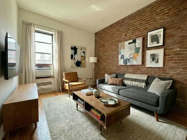 a living room with furniture a rug and a flat screen tv