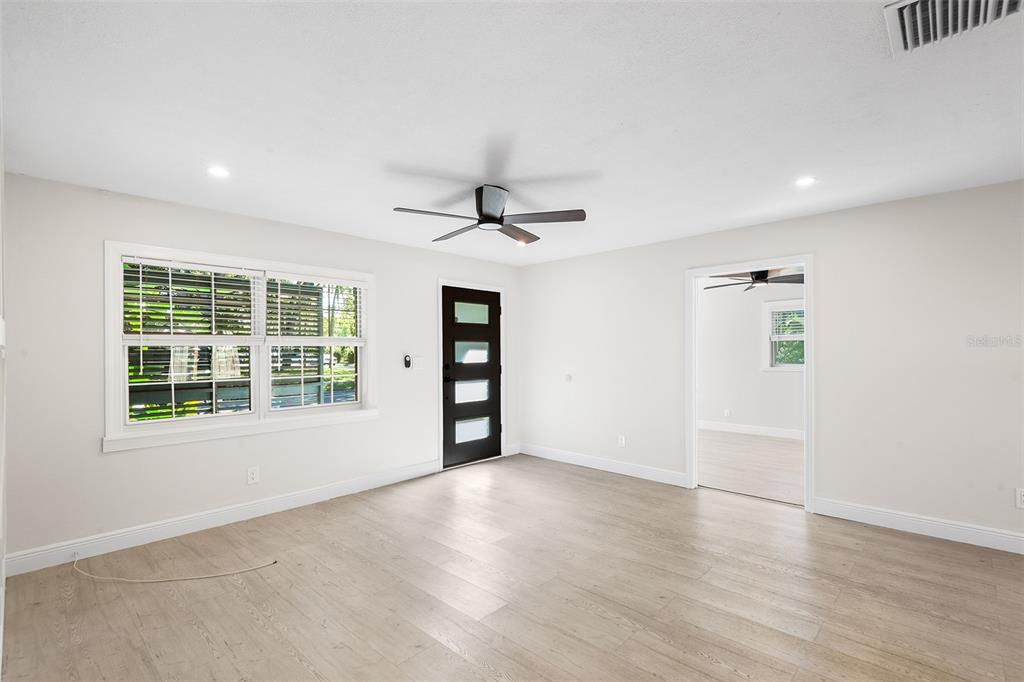 810 22nd Street North St. Petersburg, FL 33713 - Photo 4 of 37 an empty room with wooden floor and windows