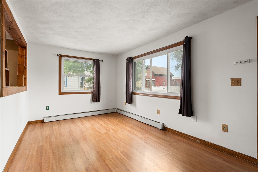 23 Logan Street Lynn, MA 01902 - Photo 11 of 27 a view of an empty room with wooden floor and a window