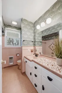 a bathroom with a granite countertop sink a toilet and a mirror