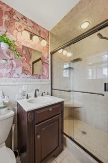 a bathroom with a sink toilet a mirror and shower