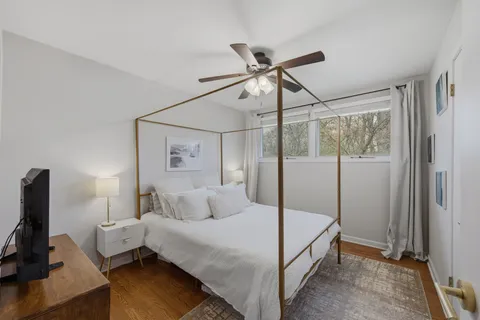 a bedroom with a bed and wooden floor