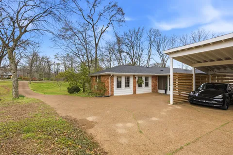a view of a house with backyard and trees