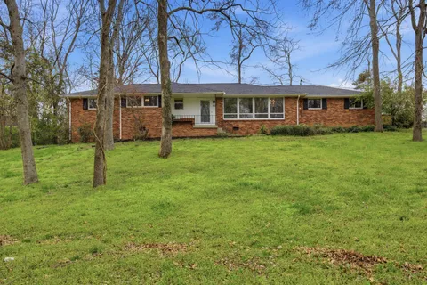 front view of a brick house with a yard