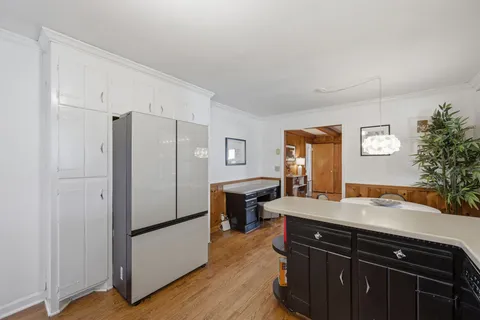 a kitchen with a refrigerator and a stove top oven