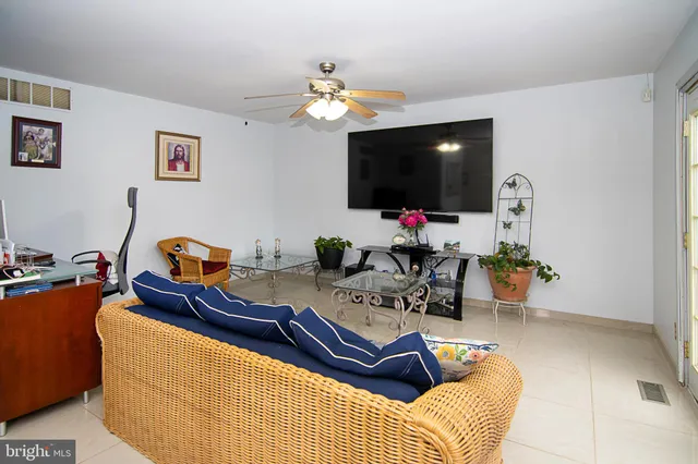 a living room with furniture a flat screen tv and a window