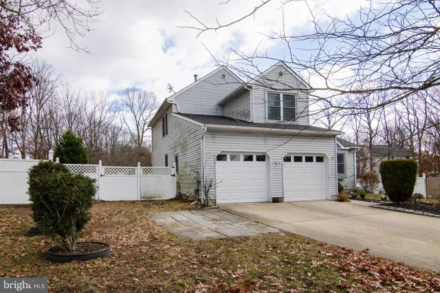 a view of a white house with a yard and a large tree