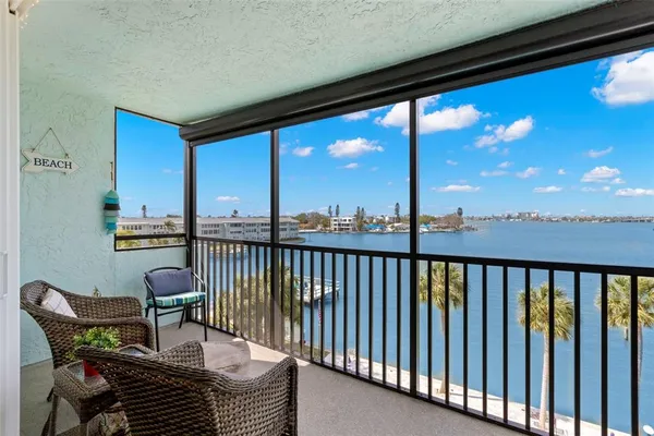 a view of a balcony with furniture and floor to ceiling window