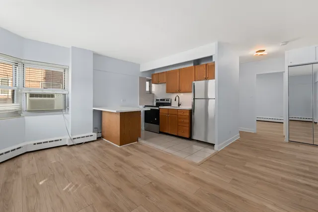 a view of a livingroom with wooden floor and electronic appliances