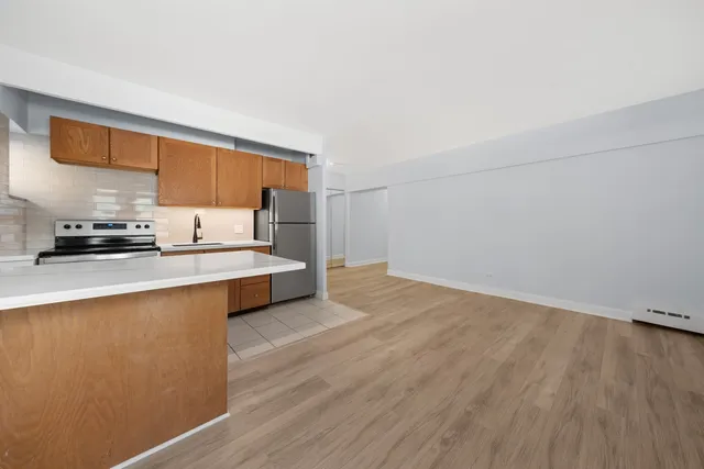 a living room with stainless steel appliances wooden floors and a view of living room