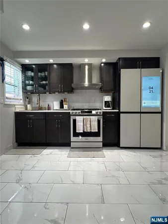 a large kitchen with stainless steel appliances granite countertop a sink and cabinets