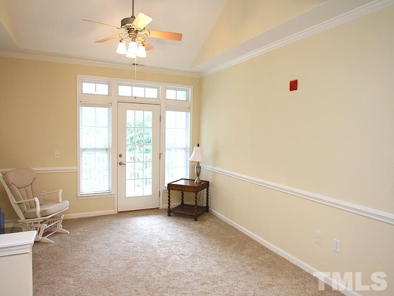 The bright living room accesses the balcony.  The ceiling fan helps keep things cool and highlights the beautiful cathedral ceiling.