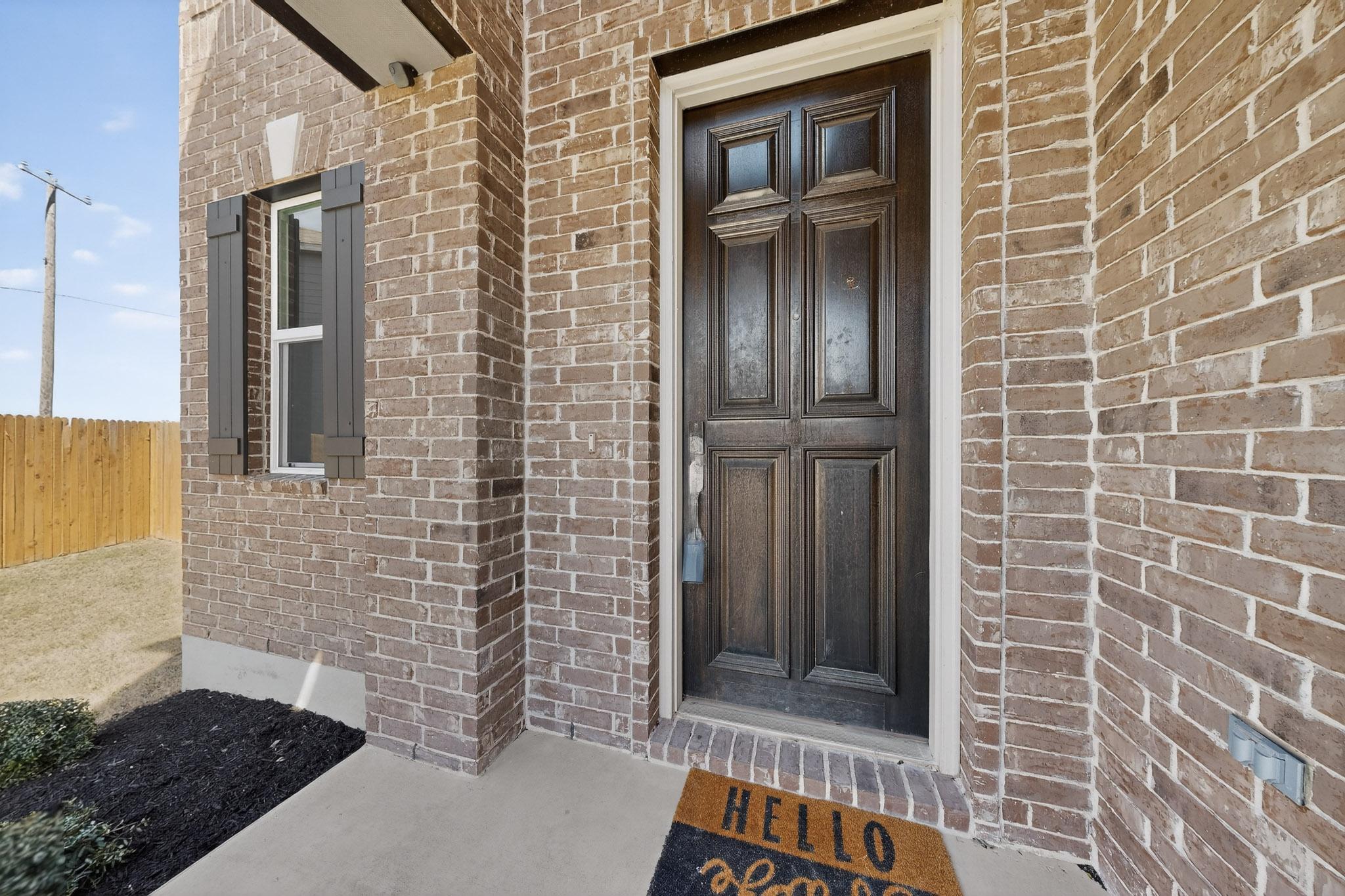 14513 Booted Eagle Pass Elgin, TX 78621 - Photo 5 of 33 Covered front porch entry with a solid wood door and welcoming curb appeal, creating a warm first impression.