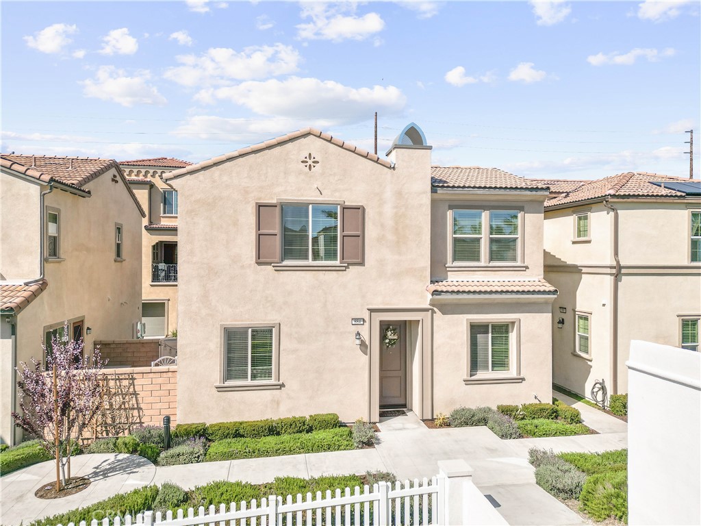 a view of a brick house with large windows and a yard