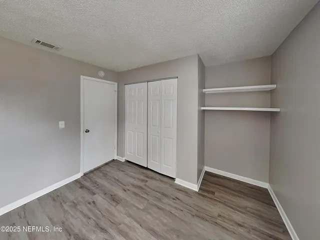 a view of an empty room with wooden floor