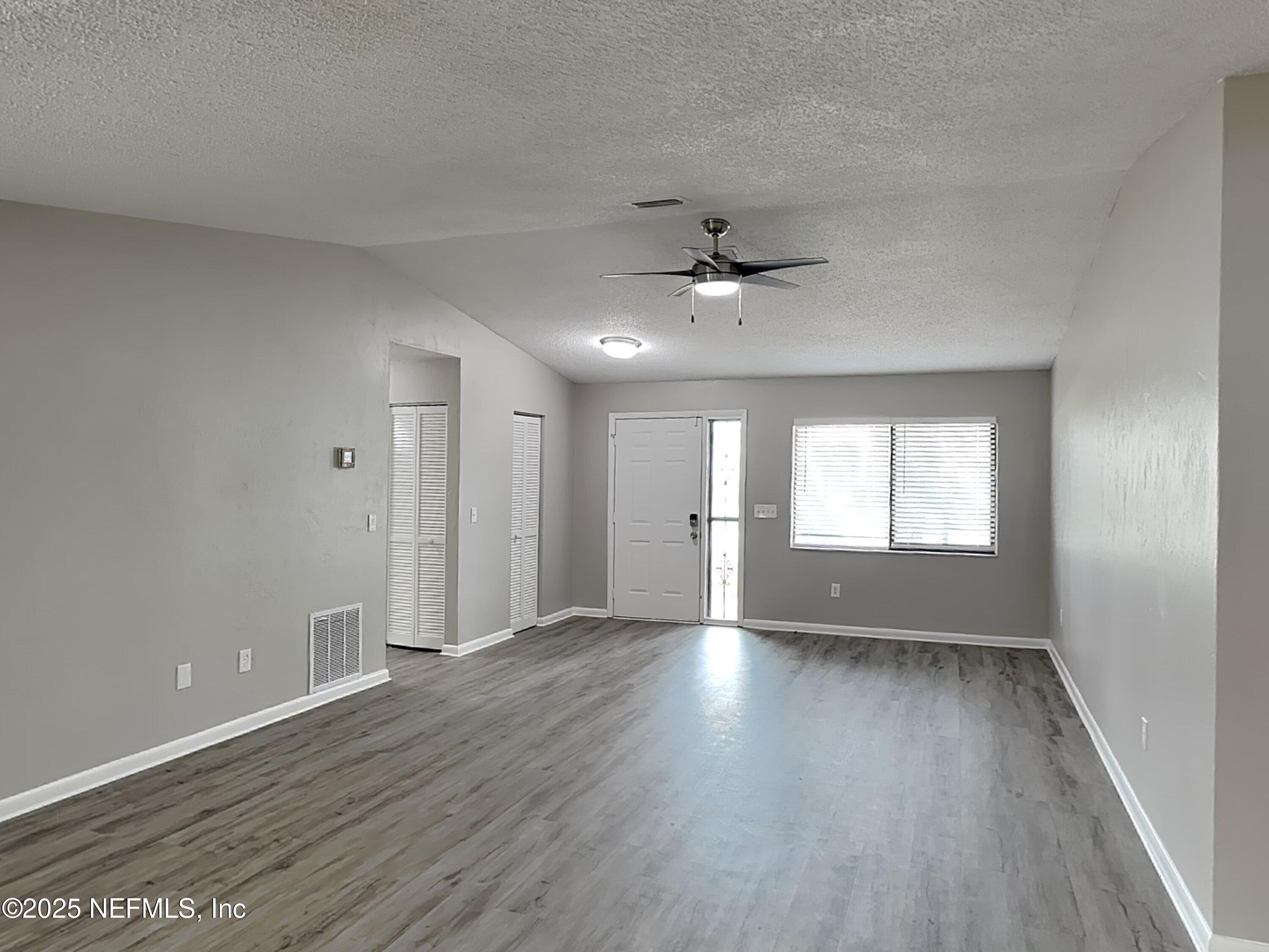 31 Folson Lane Palm Coast, FL 32137 - Photo 2 of 15 a view of an empty room with a window and wooden floor