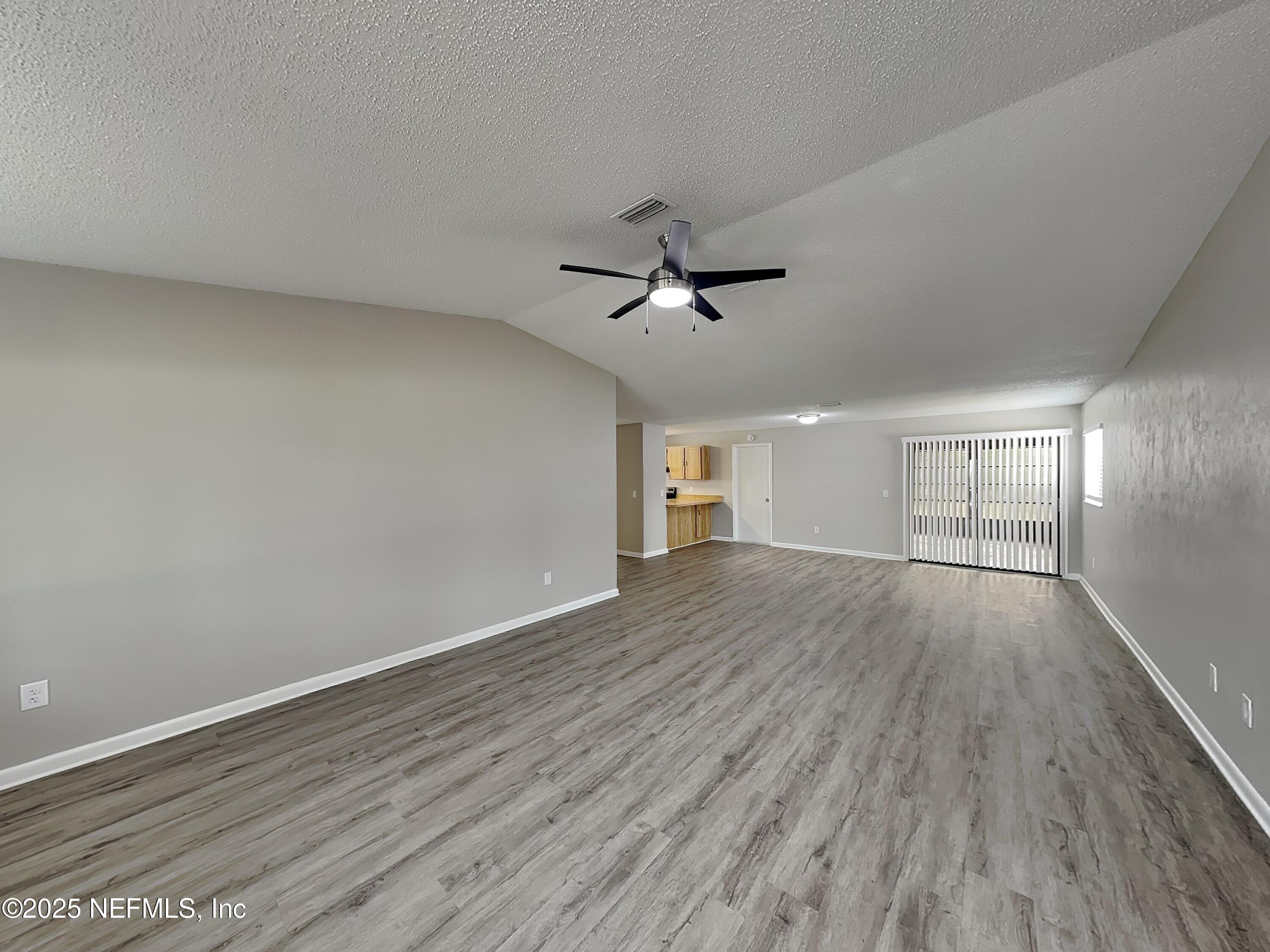 31 Folson Lane Palm Coast, FL 32137 - Photo 3 of 15 a view of empty room with wooden floor and ceiling fan