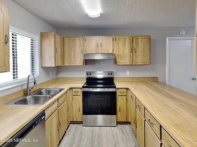 a kitchen with a stove sink and cabinets